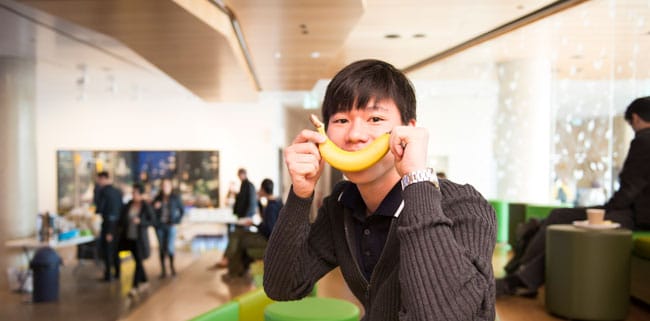 Student holding banana to his mouth