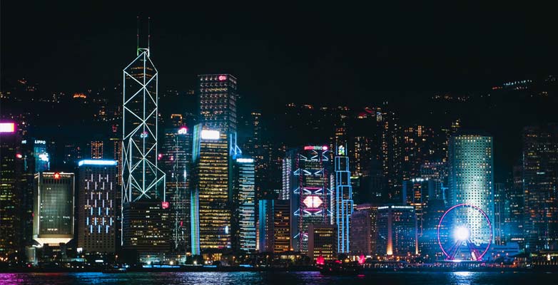 Hong Kong city skyline at night, with building illuminated in bright colours