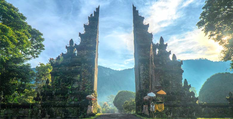An ancient stone gateway with hazy mountains in the distance