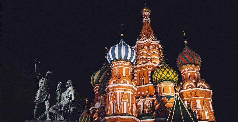 Cathedral with multiple colourful domed towers illuminated at night
