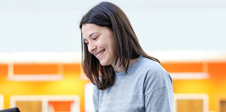 Smiling student looking at laptop