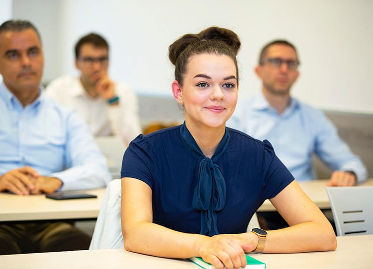 Seated students facing towards a lecturer