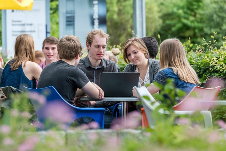 A group of students outside with a laptop