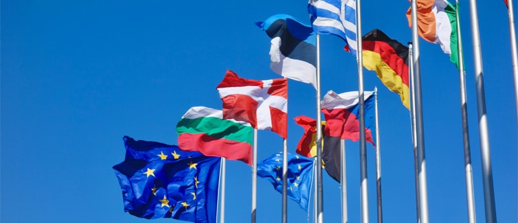 Flags of Europe on flagpoles against a blue sky background