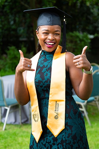 Lady giving two thumbs up during graduation ceremony
