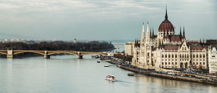 Large gothic style building next to a body of water