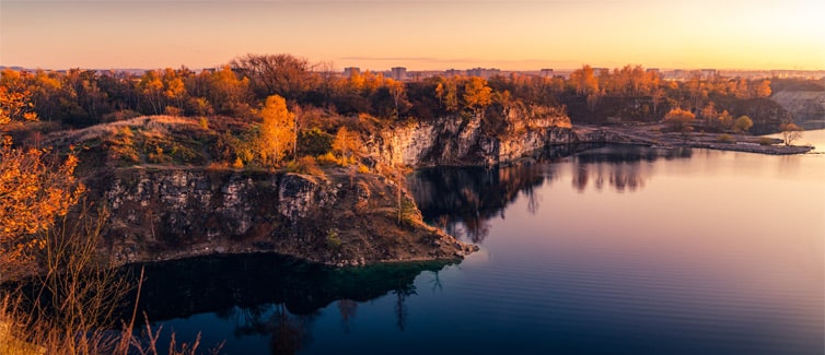 Panoramic picture of cliffs and trees next to a body of water