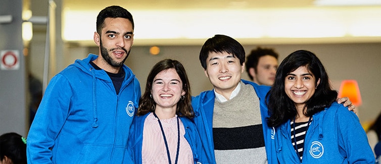 A group of four happy students in blue