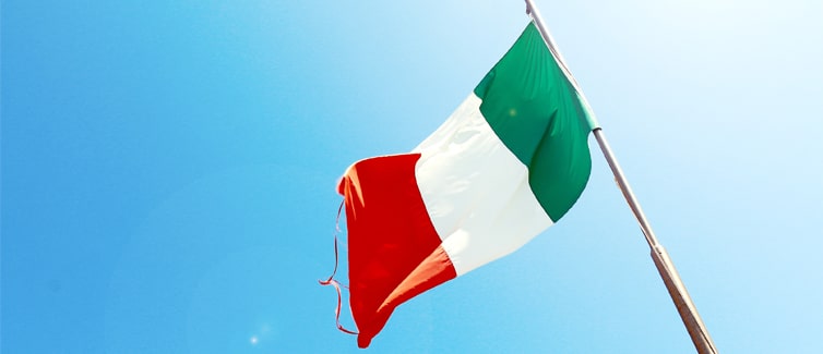 Image of the Italian flag flying on a flagpole against a bright blue background