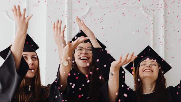 Three students celebrating graduating