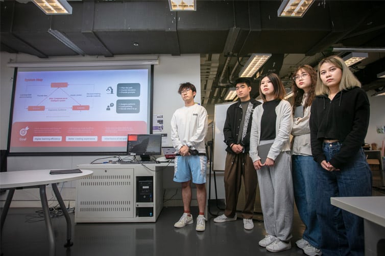 Image of 5 students standing in a row in front of whiteboard