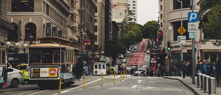 Cable car (tram) on a road surrounded by tall buildings
