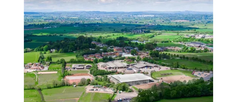 Birds eye image of green fields with Hartpury University campus buildings