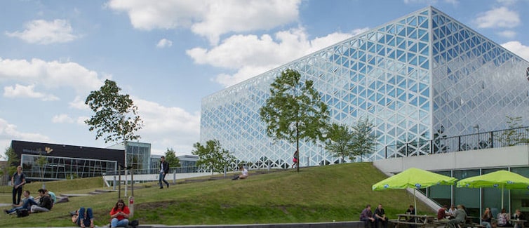 Image of a large glass building on top of a grassy hill