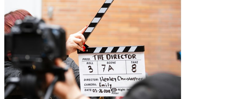 Image of a person holding a film end slate in front of a camera