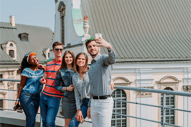 Image of students stood using a mobile phone to take a photo of themselves