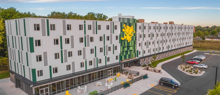 Image of a long white building with green and yellow accents on it